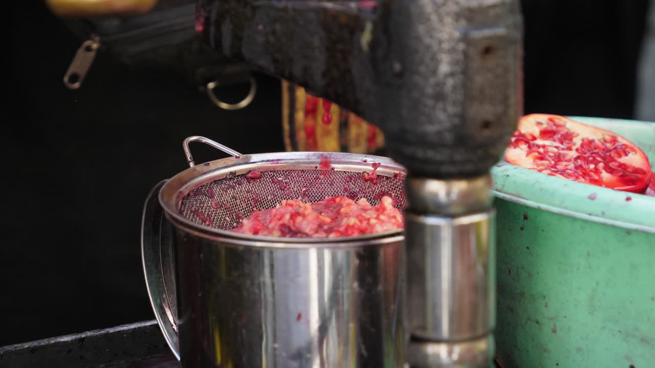 공급 업체가 그것을 세게 짜내면서 주스로 변한 생과일 몇 개를 클로즈업 샷