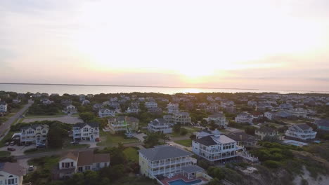 drone shot of beach houses on the coast on the outer banks of north carolina, rising and tilting downward