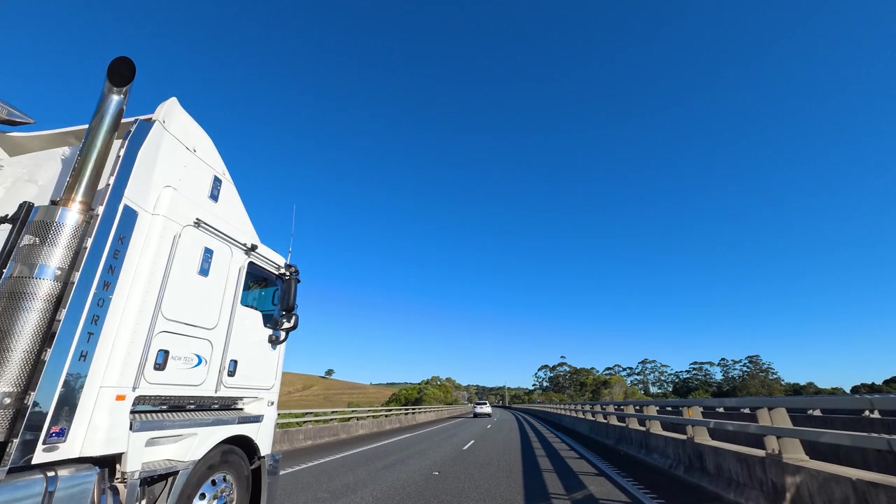 Un autoarticolato bianco viaggia lungo un'autostrada soleggiata a McLeods Shoot, Australia