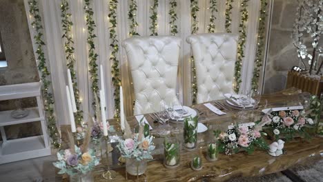 elegant wedding table setup with white chairs and floral decorations