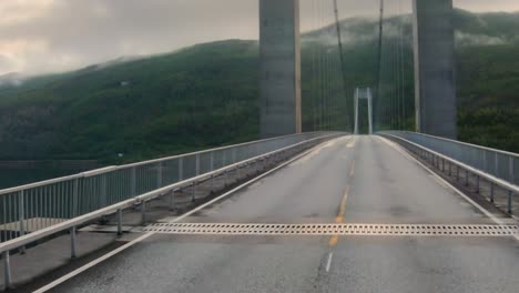 driving a car on a road in norway. vehicle point-of-view driving over the bridge.