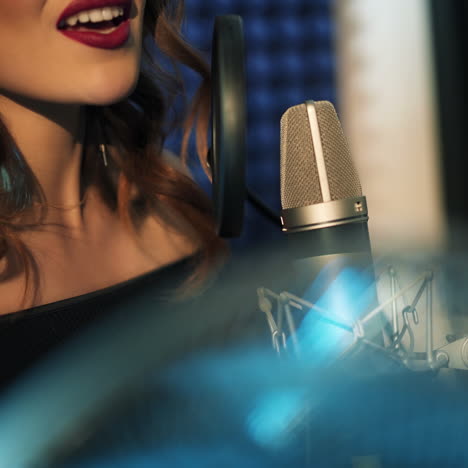 vinnitsa, ukraine - may 2019: woman singing in the recording studio. profile of a woman with a beautiful face and lips.
