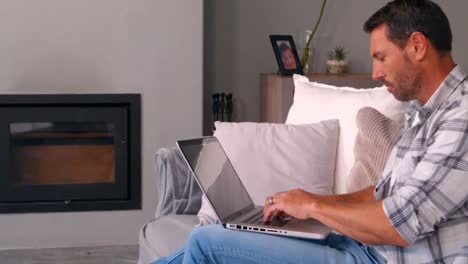 hombre usando computadora portátil en el sofá