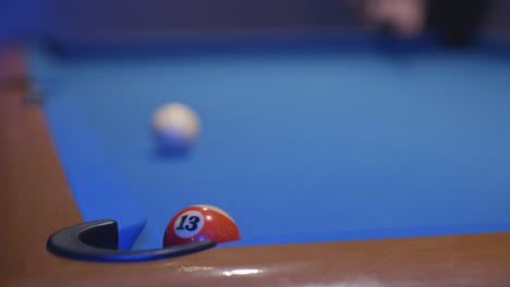 man plays snooker and puts two balls in the holes with one shot