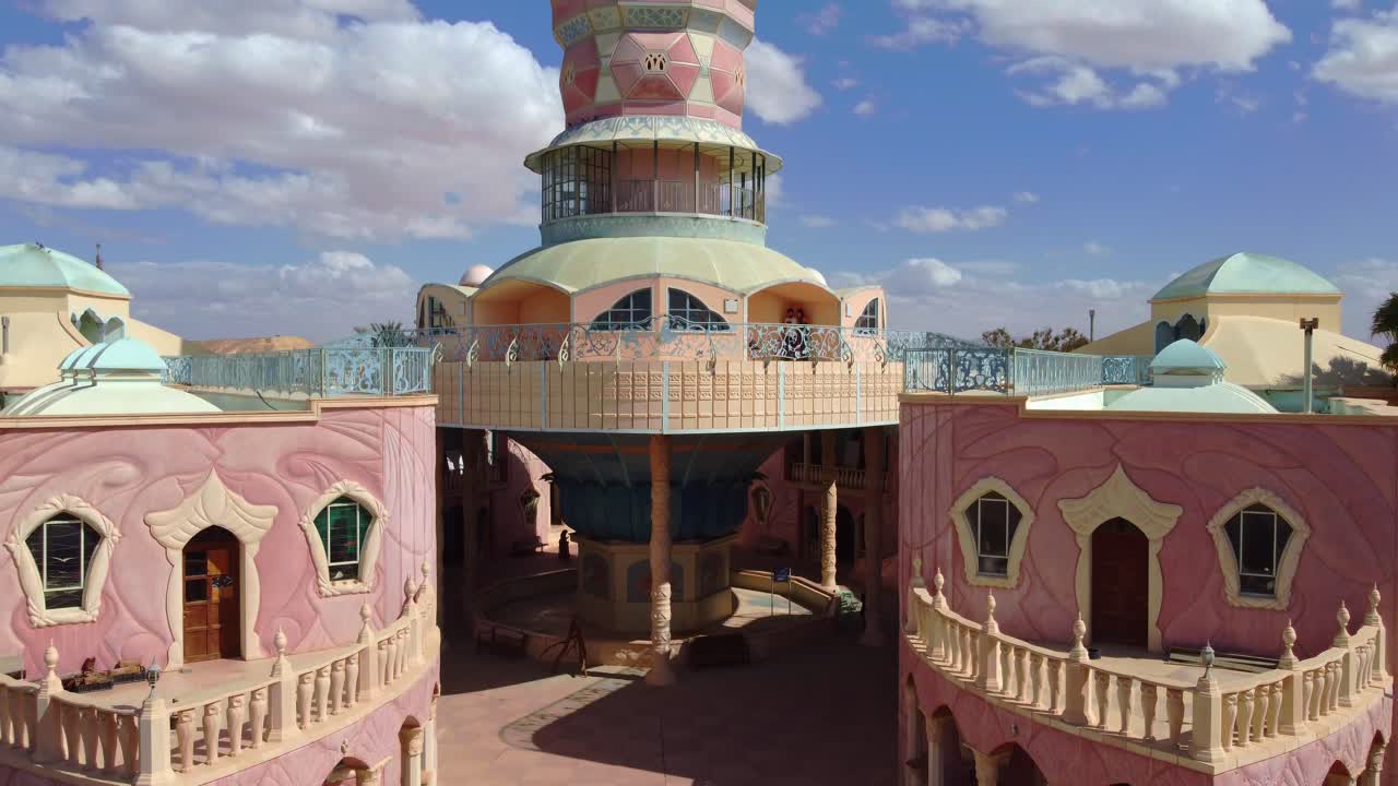 Neot Smadar Arts Center entrance and cooling tower, Arava desert landscape in the background, Revealing drone shot