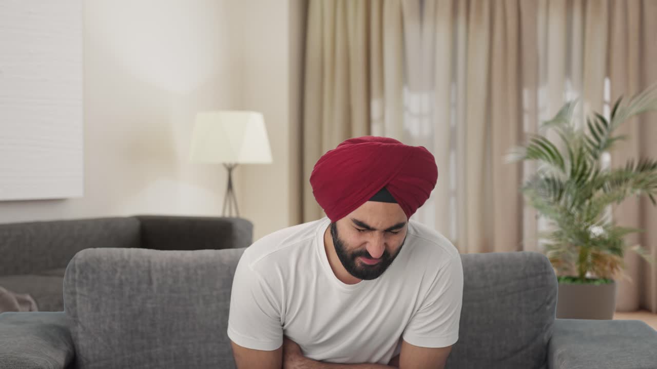 Uomo indiano sikh malato con mal di stomaco