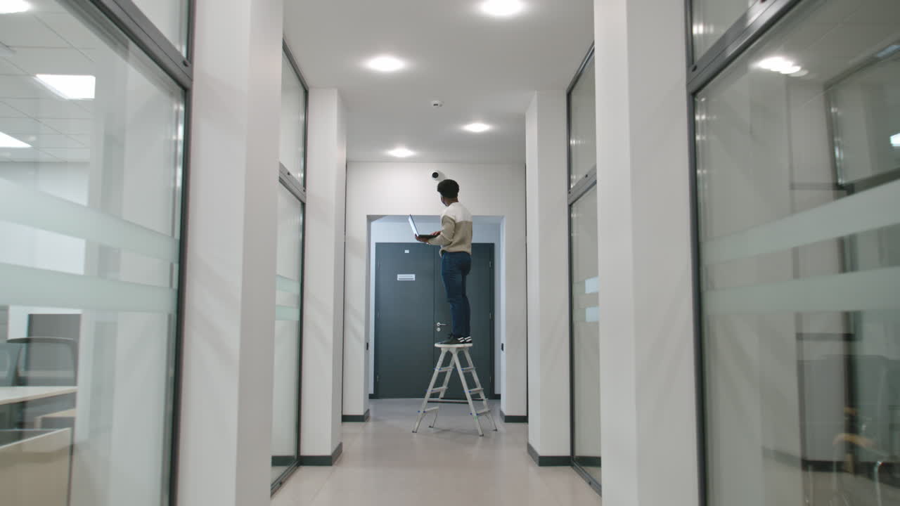 hombre de negocios trabajando en una computadora portátil en una escalera en el pasillo de la oficina