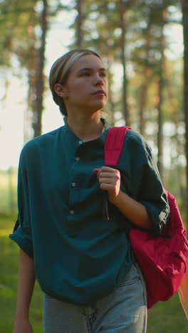 mujer caminando por un bosque tranquilo, llevando una mochila roja y mirando a la distancia con expresión serena, rodeada de árboles altos, la luz del sol proyectando un caloroso resplandor detrás de ella