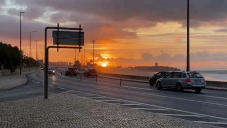 hermosa vista panorámica de los autos que circulan por las calles cerca de la playa de carcavelos en portugal al majestuoso amanecer