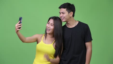 young happy asian couple video calling together