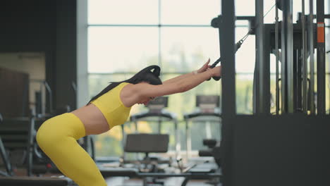 Brunette-woman-trains-her-back-and-shoulders-in-the-gym.-Monitor-your-back-and-shoulder-health.-Hand-workout