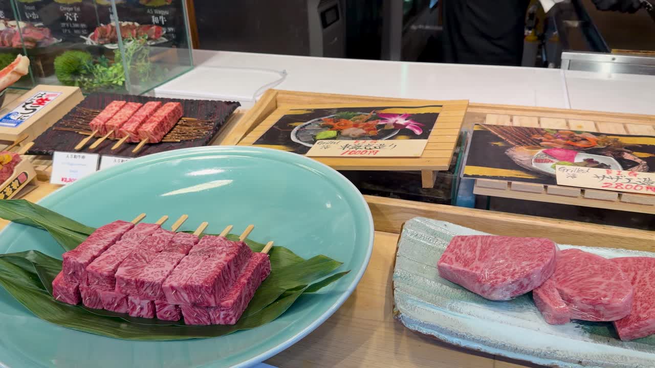 日本の市場にある高級生和牛串と神戸牛ステーキのクローズアップパンショット。