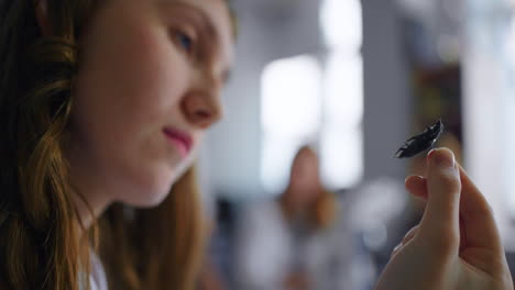 mujer sosteniendo un insecto para la clase de biología