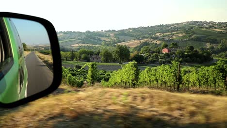mirando los viñedos italianos desde el interior de un coche mientras viaja por el campo montañoso