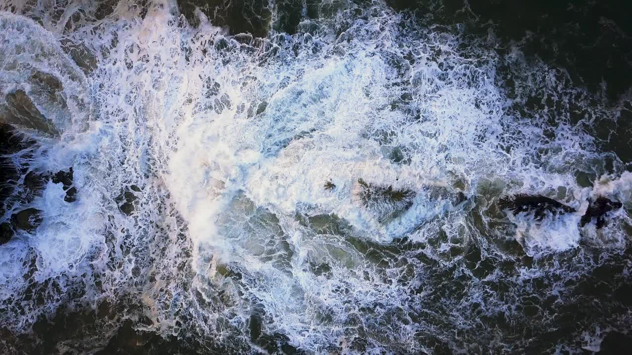 Waves crash against the rocks. An iconic place on the Atlantic coast, the Mecca of surfing on big waves.Rocks at the Nazare Lighthouse, the place with the largest waves in Europe, Nazare, Portugal