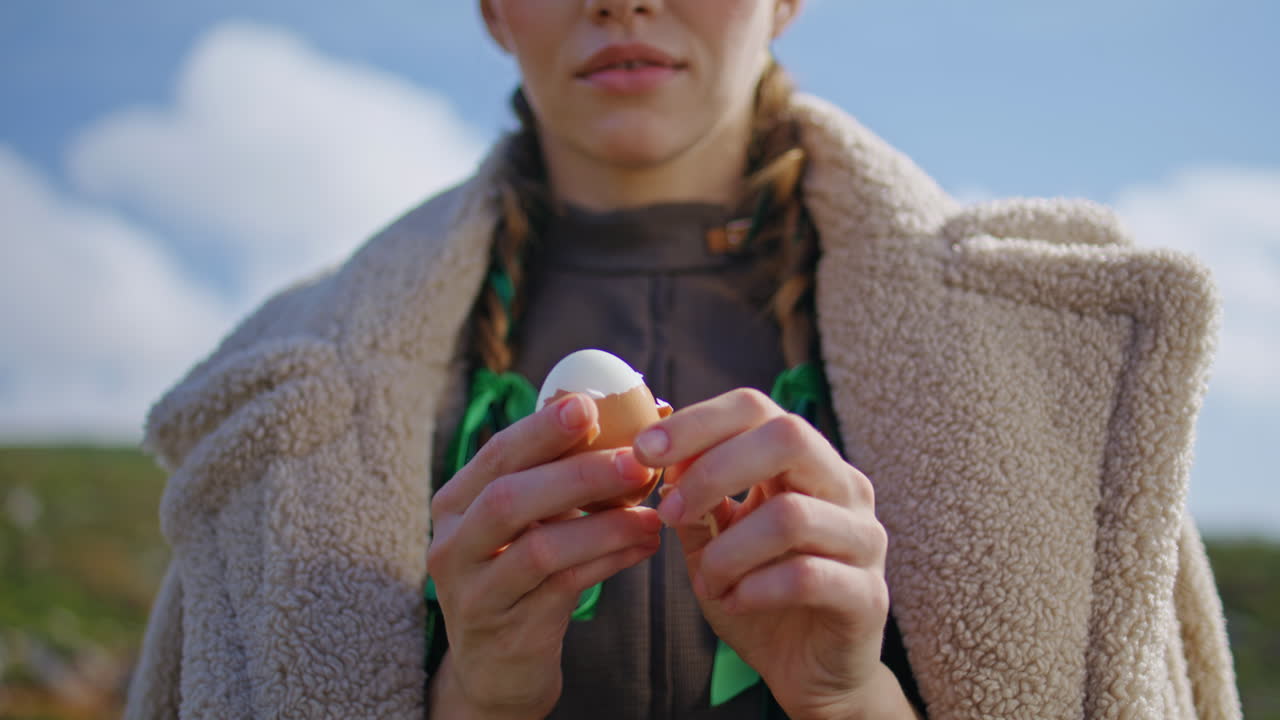 야외에서 달 질을 벗기는 손. 피크닉 소녀가 단백질 아침 식사를 하고 있습니다.