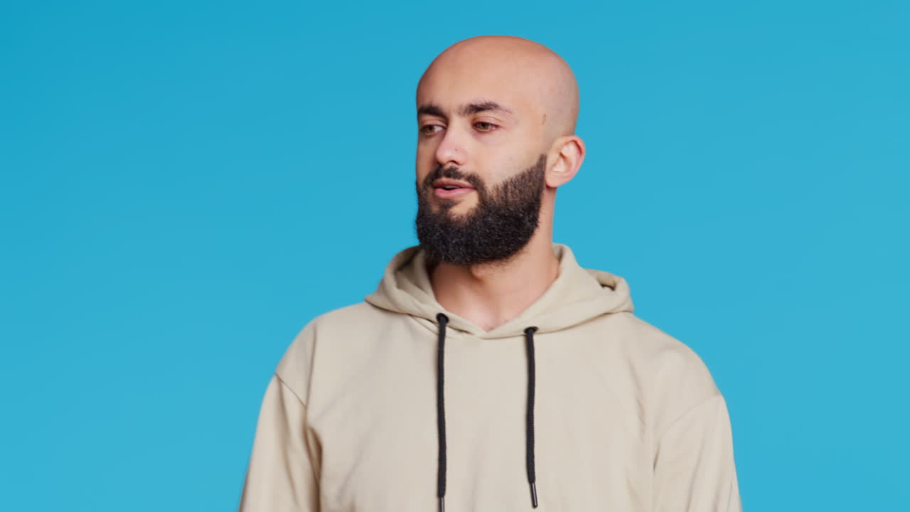 젊은 성인이 파란색 배경에서 제스처를 하지 않습니다.