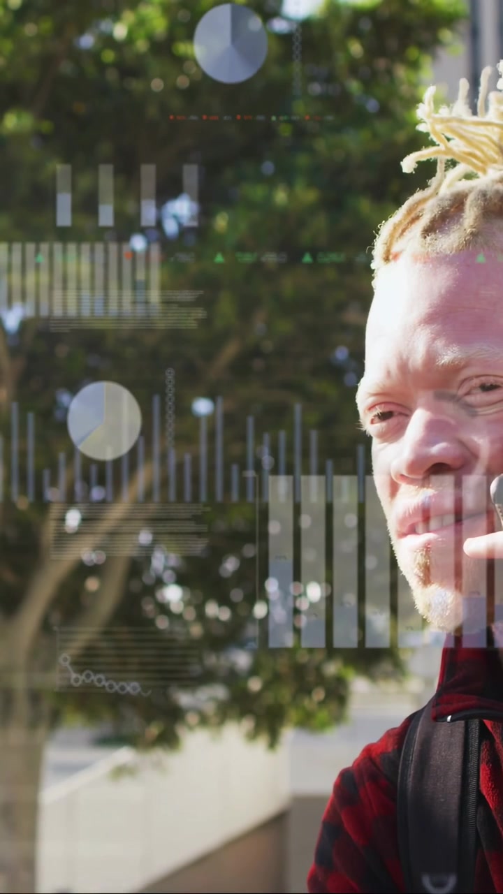 Vertical video: Man answering phone call for work, by tree, camera revealing smile, HUD overlaying
