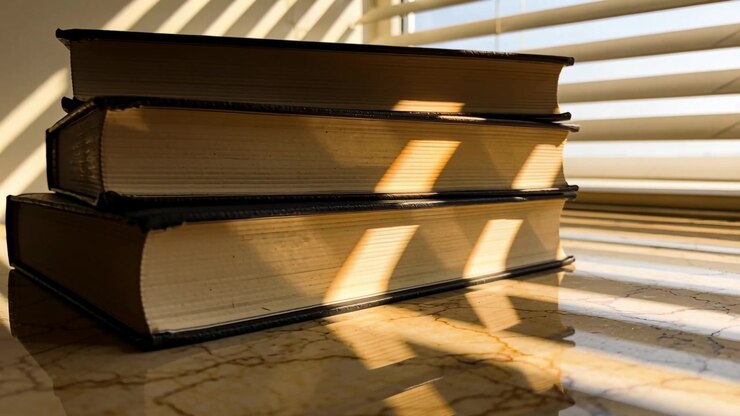 Telecamera che si allontana mostrando tre libri con copertina rigida impilati alla finestra per rivelare ombre mutevoli delle persiane.