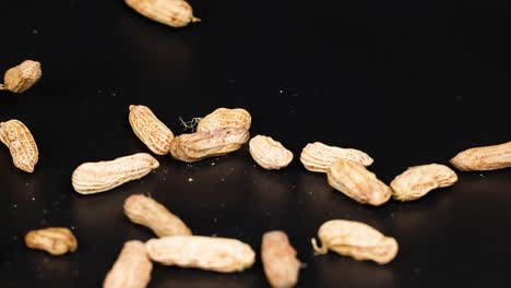 los cacahuetes se esparcen sobre un fondo oscuro