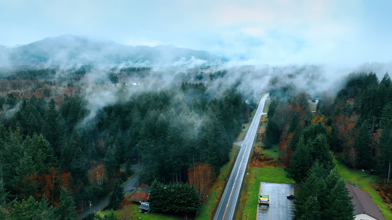 Thick haze covering the scenery of Mount Rainer national Park, Washington State, the USA. Drone footage above the beautiful nature landscape crossed by the highway with one car on.