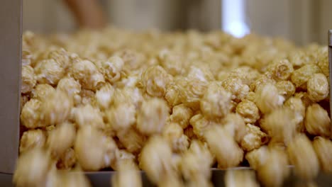 fresh golden popcorn spilling out of its cooking container like a waterfall
