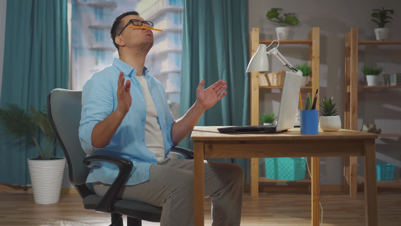 남성 사무실 직원 또는 프리랜서 직원이 근무 시간 동안 앉아서 게으르거나 미루고 있습니다.