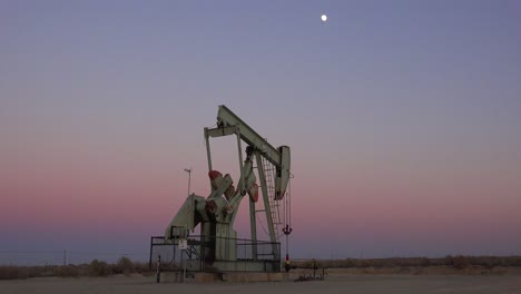 an oil derrick pumps against the night sky 1