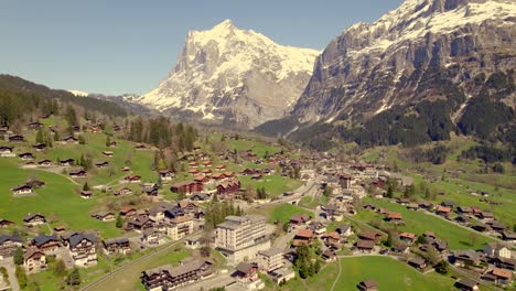 aerial drone footage raising down over wonderful mountain village in the swiss alps, in front of mount wetterhorn