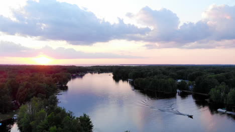 Toma-De-Drones-En-Ascenso-De-La-Puesta-De-Sol-Sobre-Un-Pequeño-Lago-En-Michigan-Durante-El-Verano