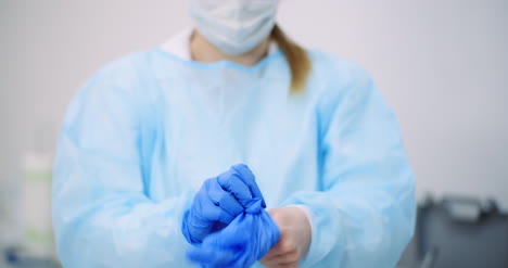 doctor puts blue protective gloves on hands at healt care clinic 1