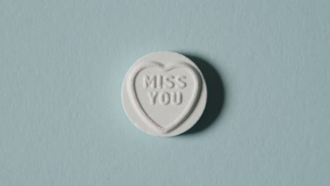 heart candy with miss you message on blue background