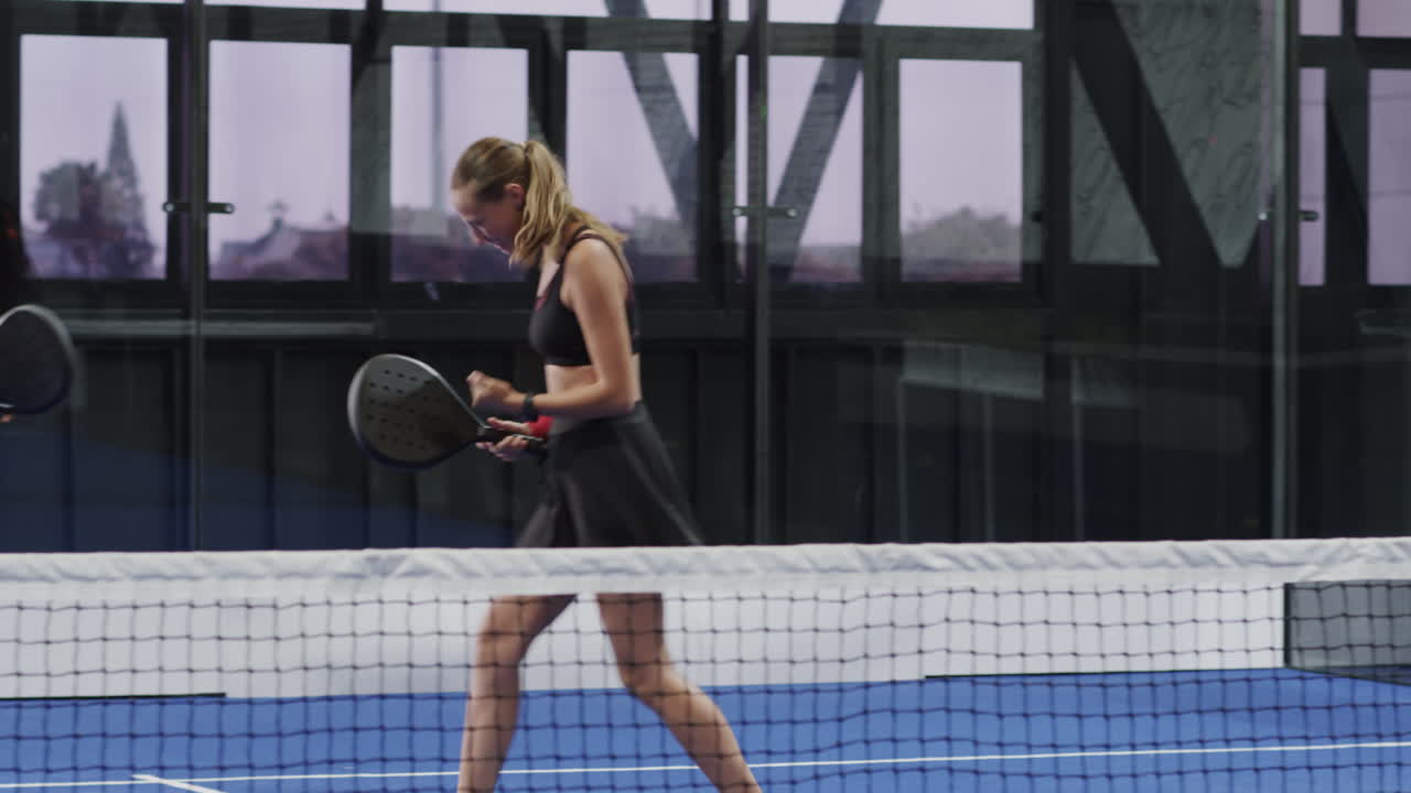 Joyful diverse players celebrating victory on indoor padel tennis court, feeling triumphant