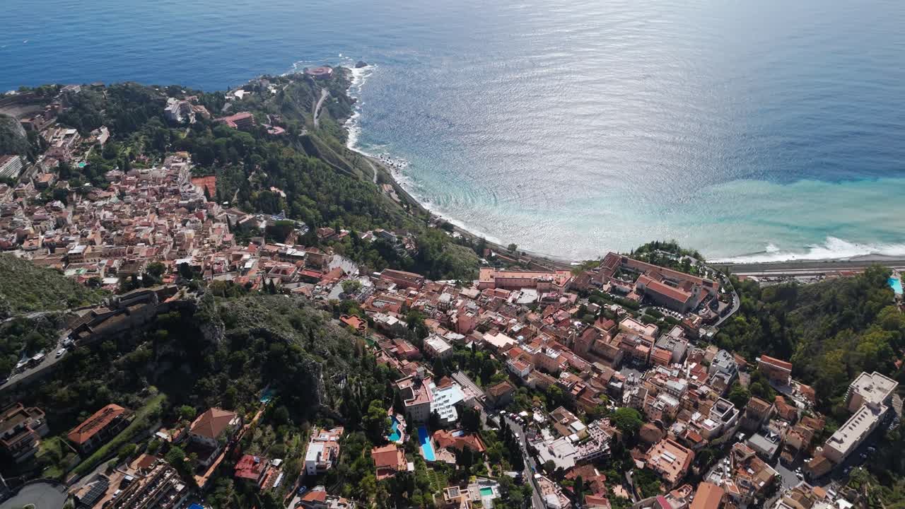 Vista aerea da drone su Castelmola e Taormina, Sicilia, filmato cinematografico 4K a 60 FPS che mostra le storiche città collinari, i tetti e la costa mediterranea con vista sul mare
