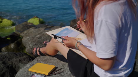 mujer pintando en la playa