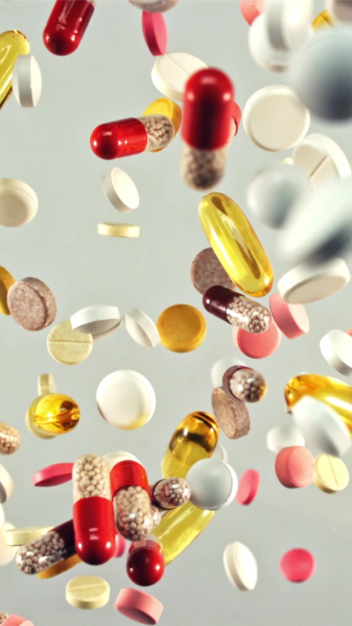 Pillole e compresse mediche colorate che cadono al rallentatore