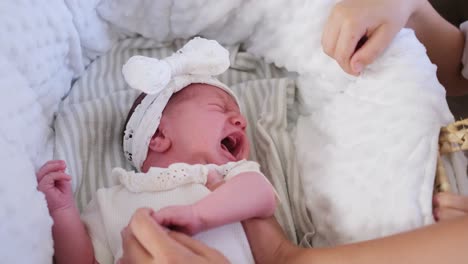 a little baby girl is crying softly while cozily wrapped in a warm blanket wearing an adorable bow a little baby girl is crying softly while cozily wrapped in a warm blanket wearing an adorable bow headband