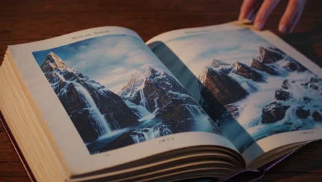 open book with mountain and waterfall images