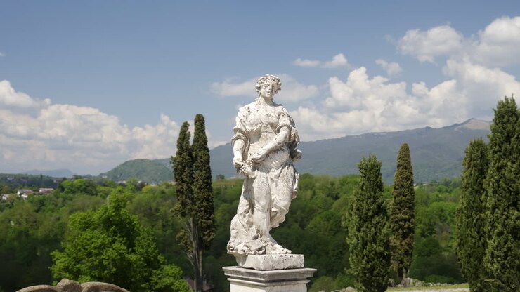 Statua di una donna in un parco con vista sulla città