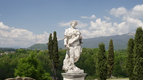 statue of a woman in a park with a city view