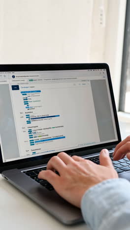 person typing on a laptop with data displayed on screen