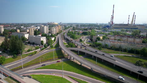 Aerial-arc-view-of-overpass-with-light-traffic-in-Gdansk,-power-station-in-back