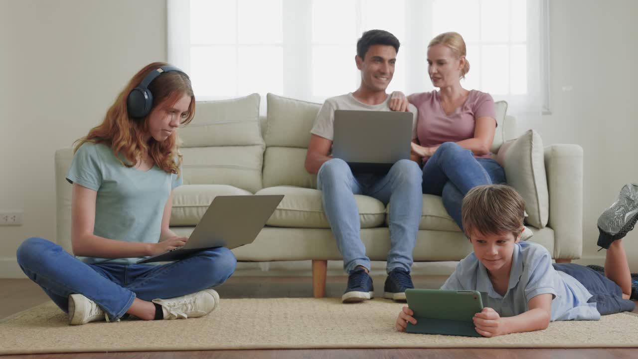 집에서 일하는 부모가 거실의 소파에서 노트북을 사용하고 아이들이 전화 앱을 사용하고 정보를 검색하고 wi-fi 5g 인터넷을 사용하고 가족이 무시하고 기기 중독 개념