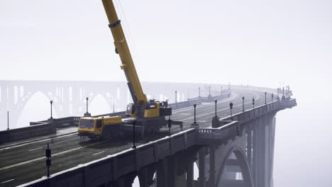 heavy crane on a foggy bridge during construction work at dawn