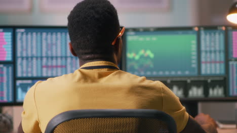 man analyzing financial data on multiple computer screens