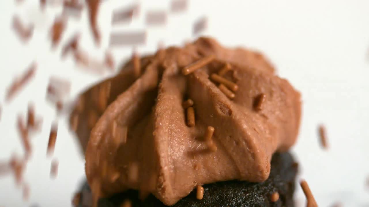 las salpicaduras de chocolate que caen sobre el pastel de chocolate