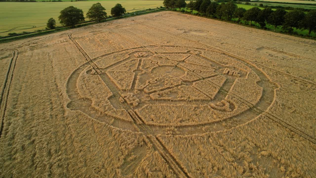 Gioco Fortnite, motivo molecolare di crop circle, vista aerea al tramonto in un campo di grano agricolo di Uffcot, orbita bassa a sinistra.