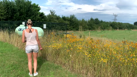 4k happy german girl collecting yellow flower from agricultural field in netherlands