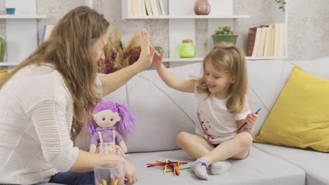 the little girl is playing a game of intelligence and her mother is helping her.