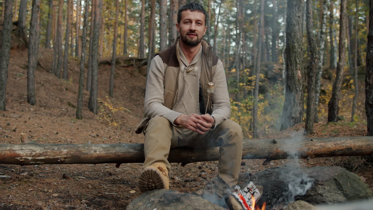 Man sitting by a campfire in the forest